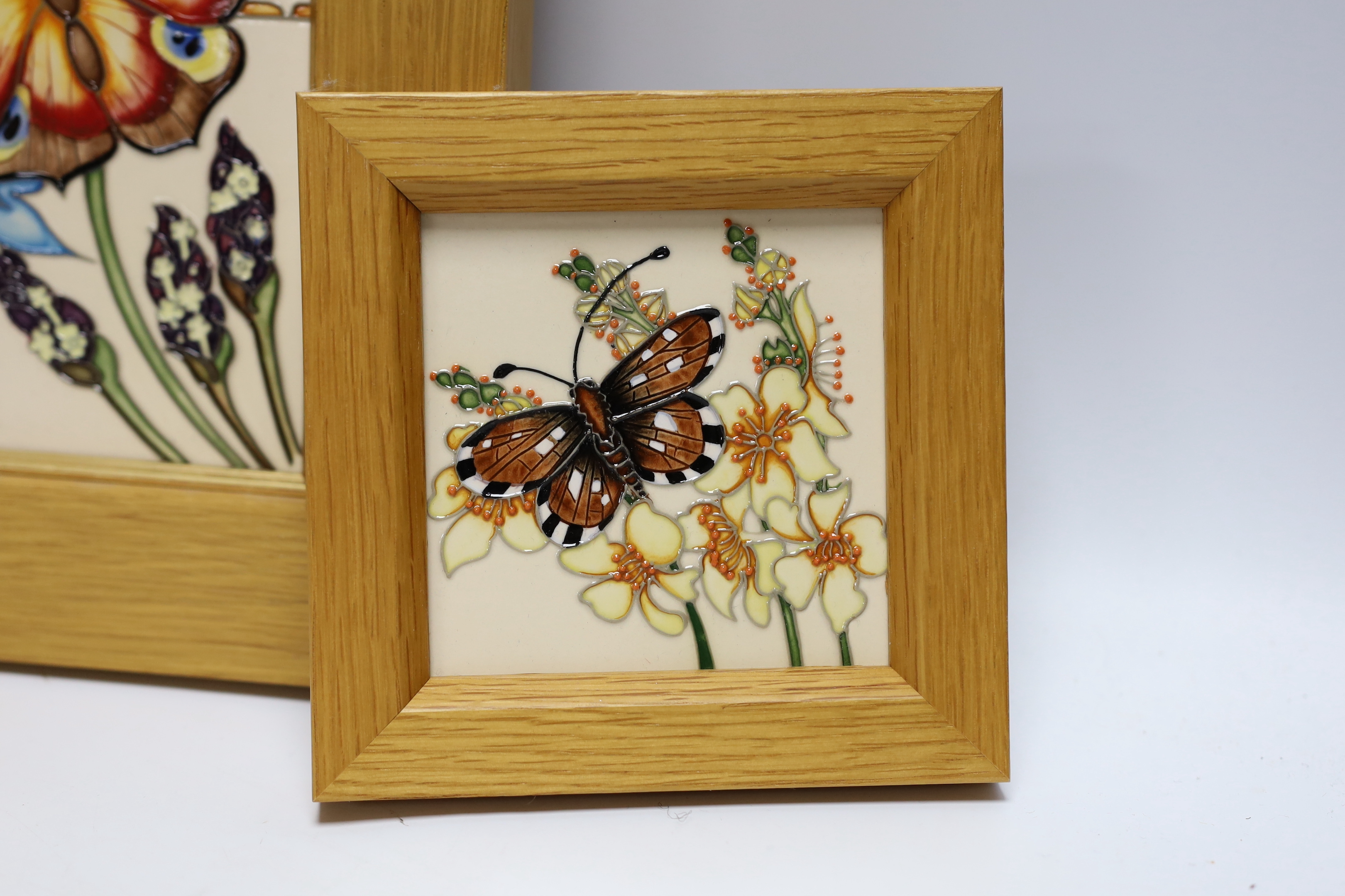 A Moorcroft Rachel Bishop wall plaque of butterflies and a similar smaller plaque, both in oak frames, largest 38 x 28cm